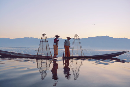 INLE LAKE, MYANMAR â JANUARY 21, 2017: Burmese Fisherman standing on a boat catching fish by a handmade net in Inle Lake, Myanmar.のeditorial素材