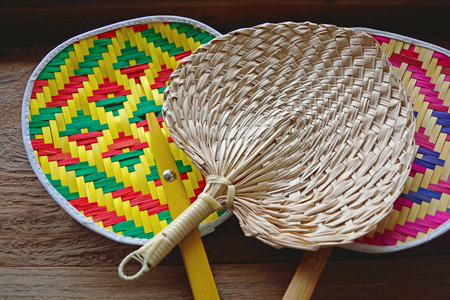 Collection of colourful handmade Thai native fan on woodの写真素材