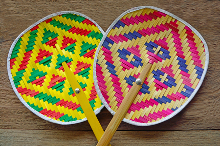 Collection of colourful handmade Thai native fan on woodの写真素材