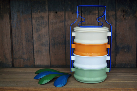 Colourful vintage tiffin carrier and spoon on wood backgroundの写真素材