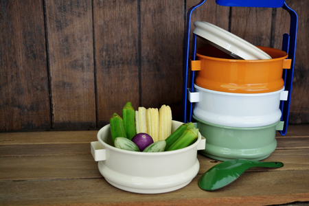 Fresh vegetables put in vintage tiffin carrier on wood backgroundの写真素材