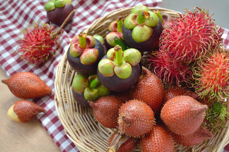 Tropical fruits, rambutan, mangosteen and salacca(palm fruit) in a basketの写真素材