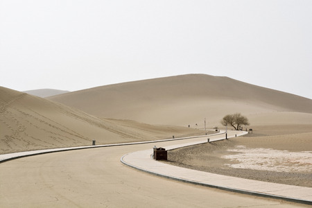 The road in  the desert  Mingsha Mountain in Dunhuang, China. This is a famous place part of silk road in Dunhuang.の写真素材