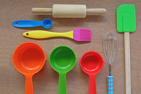 Set of kitchen and bakery tools on wood table, measuring cups, spoons, spatula, rolling, wire whisk, brushの写真素材