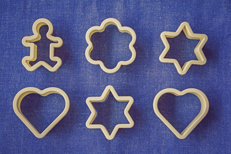 Set of fancy plastic cookie cutter on blue jean fabricの写真素材