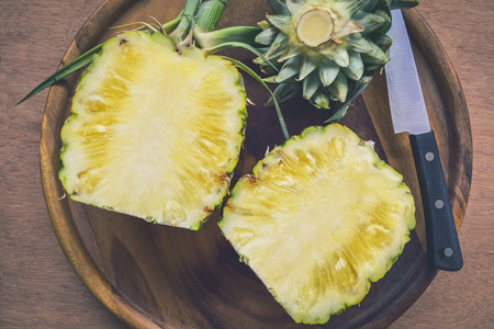 Fresh pineapple cutting on wooden plateの写真素材