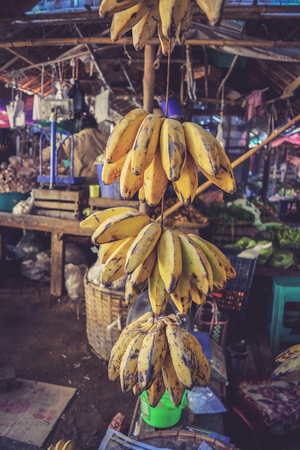 Bunch of ripe bananas hanging for sale in the local marketの写真素材