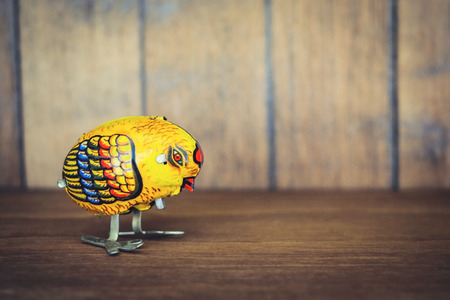 Vintage chicken tin toy on wooden backgroundの写真素材