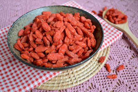 Dry goji berries in a bowl on the table, healthy foodの写真素材
