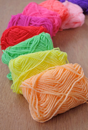 Set of rainbow color wool yarns for knitting on wooden tableの写真素材