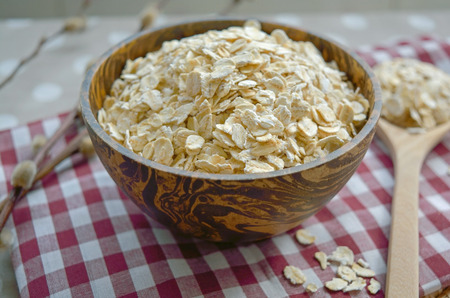 Rolled oat flakes in a wooden bowl, healthy foodの写真素材