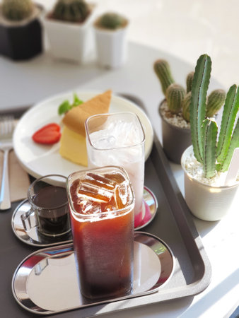 Table set for ice americano and ice chocolate milk served with home made cheese cake, Afternoon tea.の写真素材