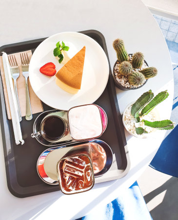 Table set for ice americano and ice chocolate milk served with home made cheese cake, Afternoon tea.の写真素材