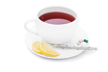 Tea with some lemon, pills and thermometer isolated on white backgroundの写真素材