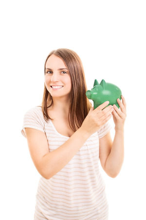 Young girl holding a piggy bank isolated on white backgroundの写真素材