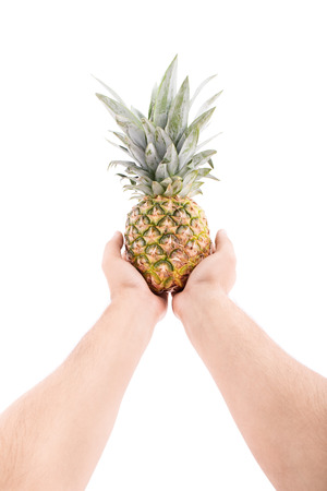 Male hands stretched outwards offering pineapple isolated on white backgroundの写真素材