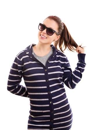 Portrait of a young girl wearing sunglasses and playing with her hair, isolated on white backgroundの写真素材