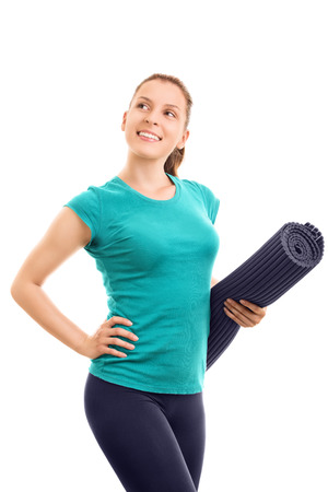 Going out for fitness exercise. Young girl wearing exercise mat isolated on white backgroundの写真素材