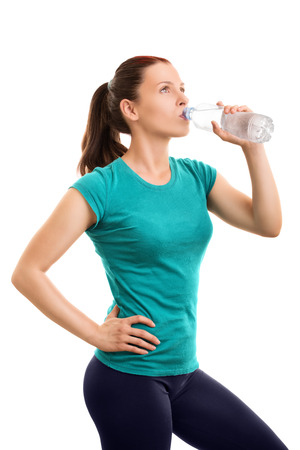 Keep yourself well hydrated while exercising. Young girl drinking water isolated on white backgroundの写真素材