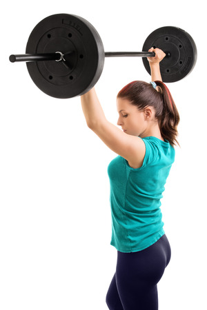 And hold! Young girl athlete holding weights up, isolated on white background.の写真素材