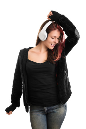 I'm dancing my favorite song, mhm. Casually dressed young girl dancing and listening music. isolated on white backgroundの写真素材