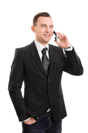 A portrait of a young businessman talking on a phone, isolated on white background.の写真素材