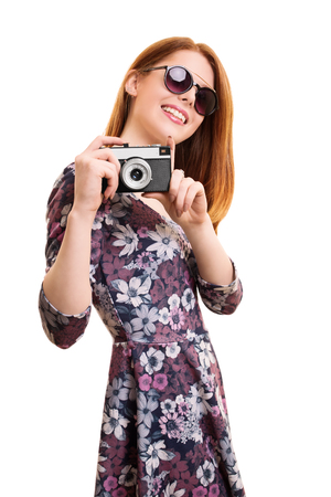 A portrait of a beautiful young girl taking a photo with a vintage camera, isolated on white background.の写真素材