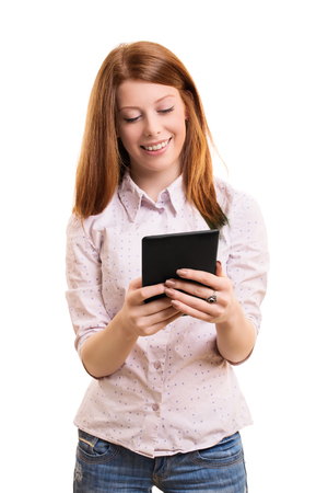 A portrait of a smiling female student holding a tablet, isolated on white background.の写真素材