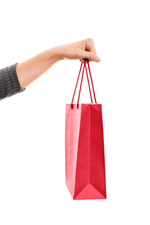 A close up shot of a female hand holding a shopping bag, isolated on white background.の写真素材