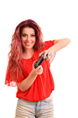 Portrait of a beautiful young girl smiling, playing on a game controller, isolated on white background.の写真素材