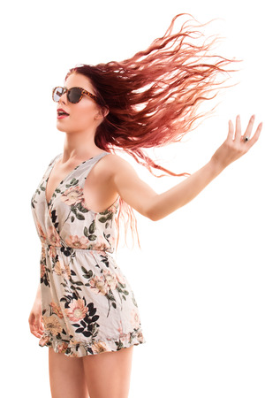 Portrait of a beautiful young girl wearing sunglasses, playing with her hair, isolated on white background.の写真素材