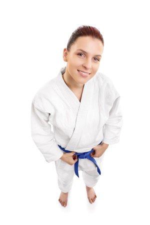 A portrait of a beautiful young female aikido fighter smiling, from top, isolated on white background.の写真素材