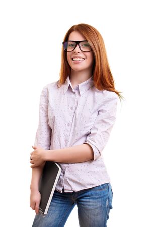A portrait of a smiling cute nerd girl with glasses, holding a notebook, isolated on white background. I can't wait to go back to school.の写真素材