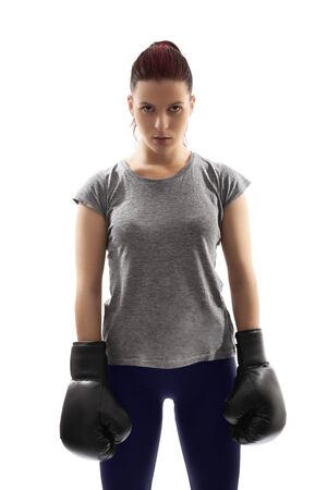 A portrait of a beautiful young girl with boxing gloves under harsh lightning, isolated on white background.の写真素材
