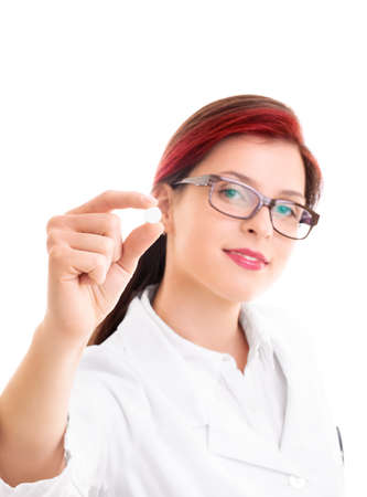 Smiling young doctor holding a pill, isolated on white background. Healthcare, medical concept.の写真素材