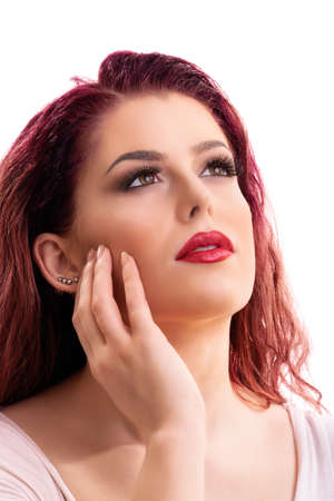 Sensual portrait of a beautiful redhead young woman with soft clean make up looking up, isolated on white background. Daydreaming, thinking concept.の写真素材