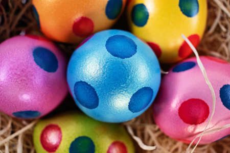 Top close up view of colourful Easter eggs with polka dots in a basket, isolated on white background. Easter celebration concept.の写真素材