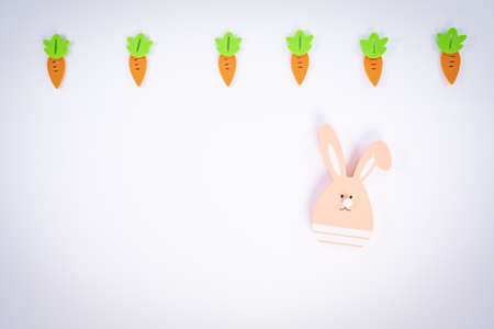 Easter pattern made with carrots and a cute Easter bunny on white background. Creative minimal holiday flat lay concept. Spring holidays concept. Top view. Copy space.の写真素材