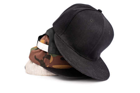 Four baseball snapback hats in different colors stacked on top of each other, isolated on white...