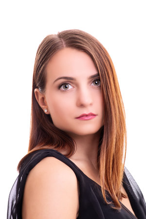 Close up portrait of a beautiful young woman in an elegant black blouse, looking directly at the camera, isolated on white background. Fashion, makeup, model, elegance concept.の写真素材