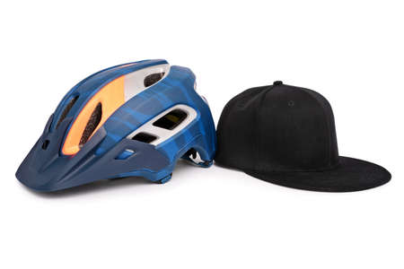 Bike helmet and a baseball snapback hat side by side, isolated on white background. Fashion and head accessories concept.の写真素材