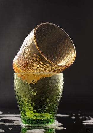 two coloured glasses are cleaning on the black backgroundの写真素材