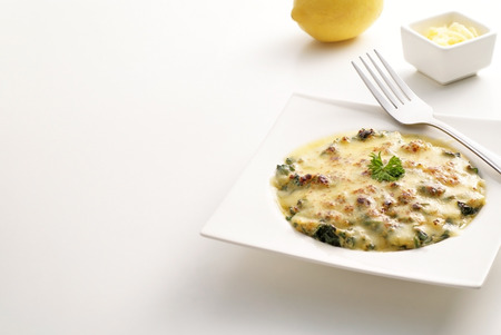 Baked spinach with cheese on white の写真素材