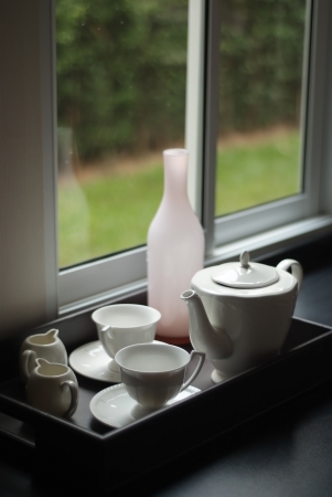 Teapot and accessories located near the windowの写真素材