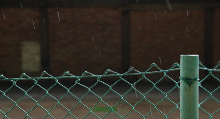 Fence barb with the building in the rainの写真素材
