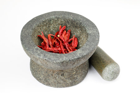 Mortar and pestle with dried chili on white backgroundの写真素材