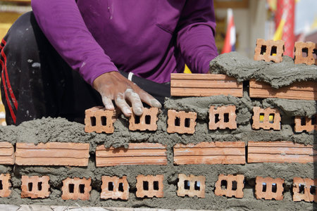 material; texture; close up; hand; incomplete; stack; coating; handyman; repairing; equipment; exterior; stone; build; layer; block; skill; process; tool; bricklayer; bricklaying; mortar; craftsman; masonry; mason; builder; laborer; brickwork; occupation; industry; working; brick; man; worker; trowel; wall; workplace; concrete; house; construction; plaster; level; cement; industrial; workman; spatula; installing; building; professional; cementの写真素材