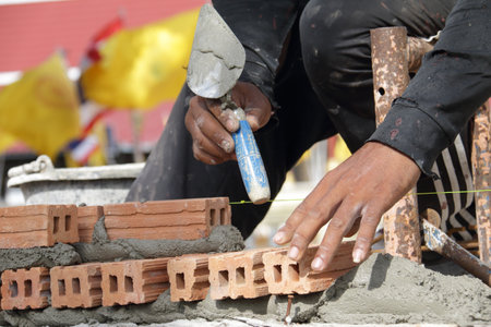 The construction workers lay bricks plaster and build wallsの写真素材