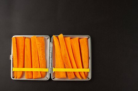 Cigarette case with carrot slices Concept of quitting smoking, healthy lifestyleの写真素材