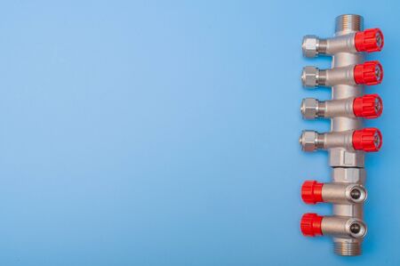 A steel supply manifold with red regulators on a blue background.の写真素材